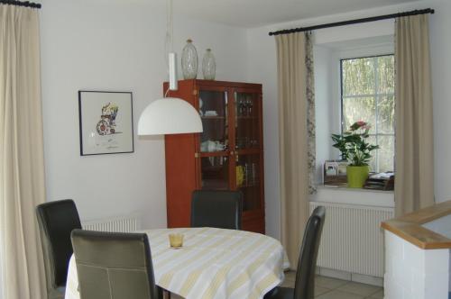 a dining room with a table and chairs and a window at Gästehaus Eulennest in Großenwörden