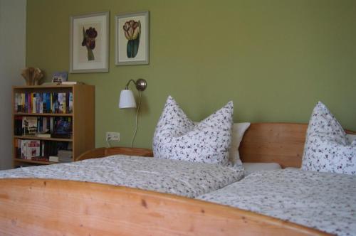 um quarto com uma cama com almofadas em Gästehaus Eulennest em Großenwörden