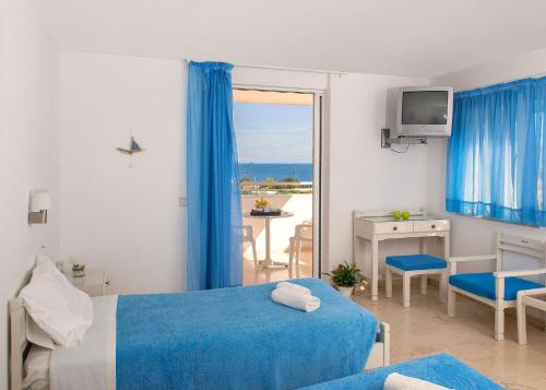 a hotel room with a bed and a view of the ocean at Primavera Paradise Apartments in Agios Nikolaos