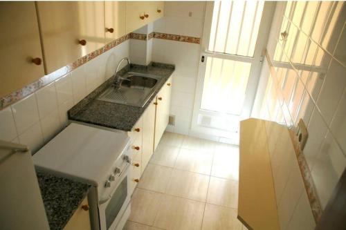 a small kitchen with a sink and a stove at Apartamentos los Boliches in Puerto de Mazarrón