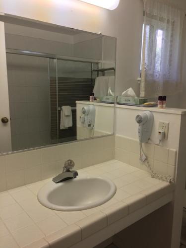 a bathroom sink with a mirror and a phone at Oak Motel in Palo Alto