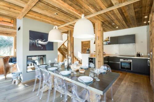 une salle à manger et une cuisine avec une table et des chaises dans l'établissement Chalet Alexandra, aux Houches