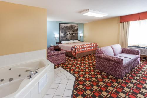 Habitación de hotel con bañera y cama en Econo Lodge, en Chillicothe