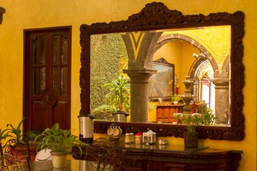 a mirror on a wall with a table with plants at Hotel Casa Dulce Maria in Tequila
