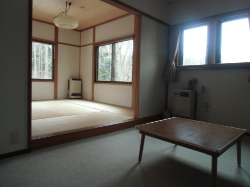 Habitación con espejo grande y mesa. en Raumu San-so, en Omachi