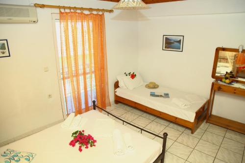 a small room with two beds and a mirror at Homer Studio in Nydri