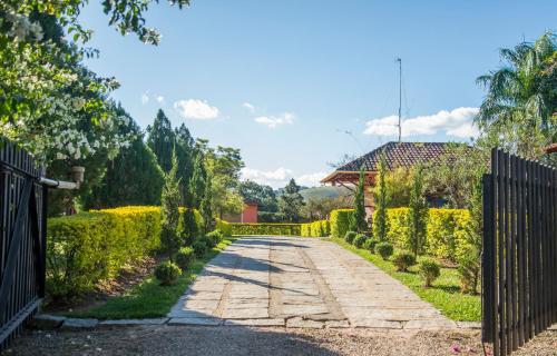 a garden with a fence and a walkway at Pousada Vila Minas in Itanhandu