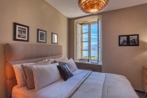a bedroom with a large bed with a large window at U Palazzu Ghejenuvese in Bastia