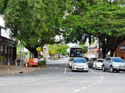 a street with cars and a bus driving down a street at Best Western Airport 85 Motel in Brisbane