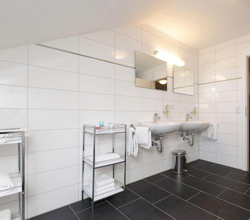 a white bathroom with a sink and a mirror at Pension Arkade in Neckarsulm