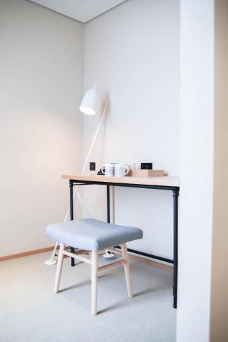a desk with a chair and a table with a lamp at Mega Hotel in Chiayi City
