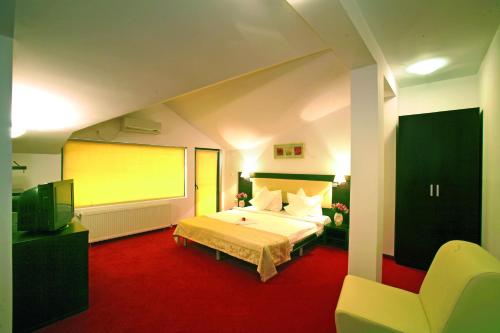 a bedroom with a large bed and a yellow screen at Pension Siera in Mamaia Sat/Năvodari