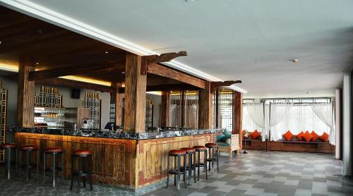 a bar with stools in a room with at Fusion Suites Phuket Patong in Patong Beach