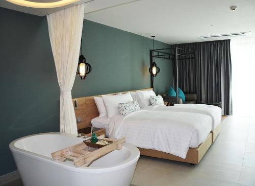 a bedroom with two beds and a bath tub at MAI HOUSE Patong Hill - SHA Extra Plus in Patong Beach