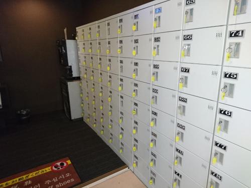 uma parede de cacifos num quarto em Atsugi Capsule Hotel em Atsugi