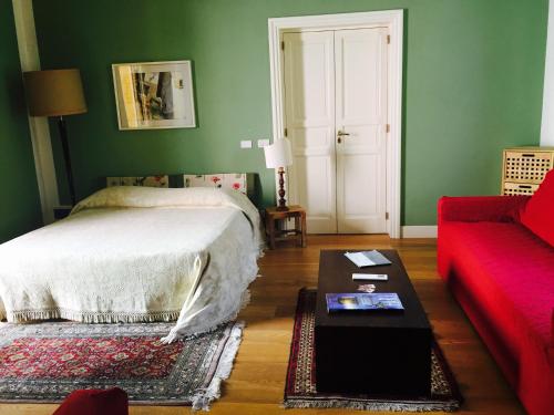 マルサラにあるB&B Case a San Matteoのリビングルーム(ベッド1台、赤いソファ付)