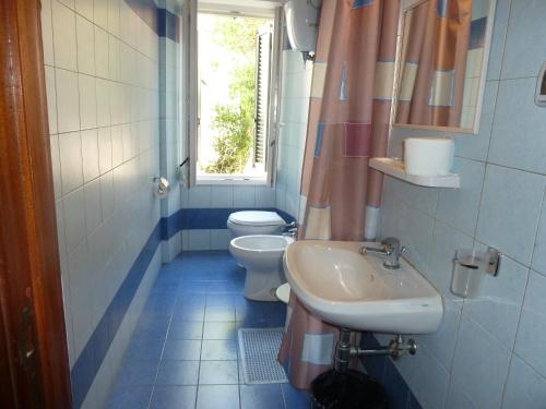 bagno con due servizi igienici, lavandino e finestra di Hotel Bolognese a Foligno