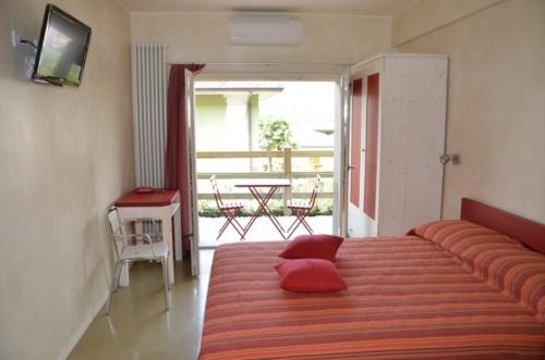 een slaapkamer met een groot bed met rode kussens erop bij Bikapi in Garda