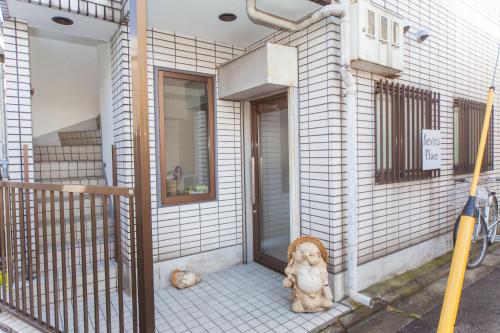 a dog sitting on the front porch of a house at Kevin's Place in Kyoto