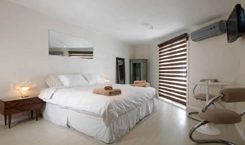 a bedroom with a white bed with a towel on it at Casabierta in Buenos Aires