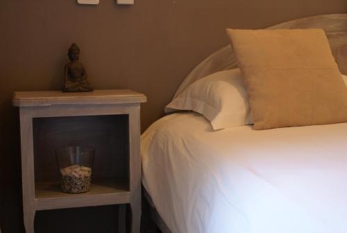 a bedroom with a bed and a nightstand next to a bed at Le Petit Manoir Hotel Provence in Les Angles Gard