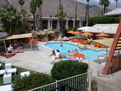 a group of people playing in the pool at a resort at Aloha Hotel Palm Springs in Palm Springs
