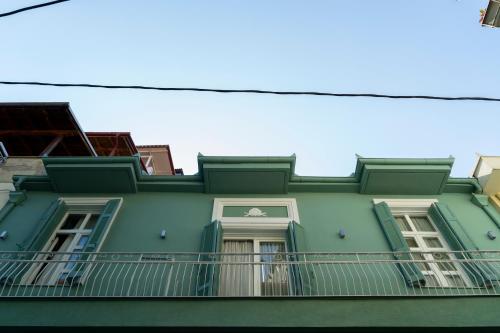 a green building with a balcony on top of it at Le Bijou Luxury Rooms & Suites in Veria