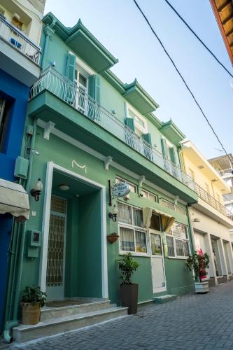 a green building with a balcony on a street at Le Bijou Luxury Rooms & Suites in Veria