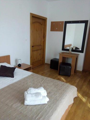 a bedroom with a bed with two towels on it at Pensiunea Codruta in Carpinis