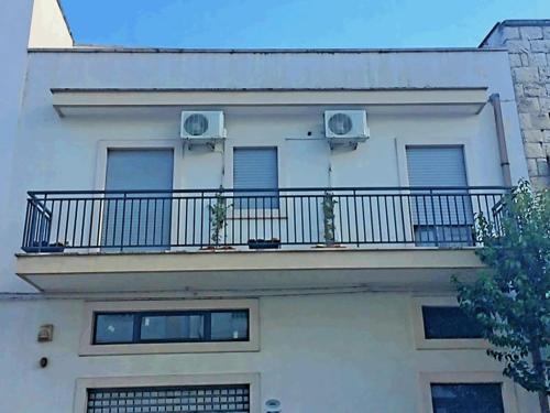 a white building with a balcony with two windows at Federicocasa in Alberobello