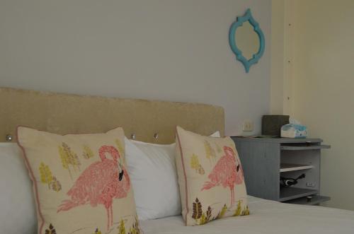 a bed with two pillows with pink birds on it at Grapefruit Heping Guesthouse in Hualien City