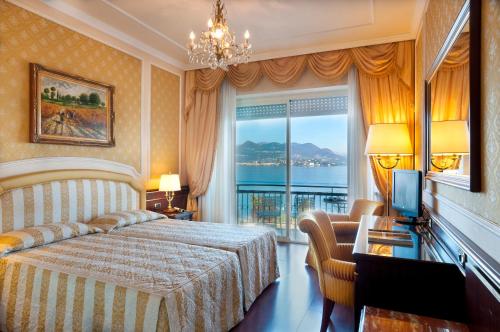 een hotelkamer met een bed en een groot raam bij Grand Hotel Bristol in Stresa