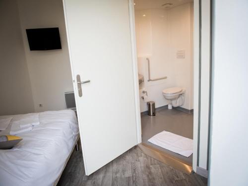 - une chambre avec un lit et une salle de bains avec des toilettes dans l'établissement Logis Hotel Restaurant Le Relais Fleuri, à Vervins