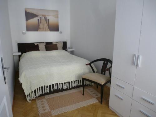 a small bedroom with a bed and a chair at Charming Viennese Home in Vienna