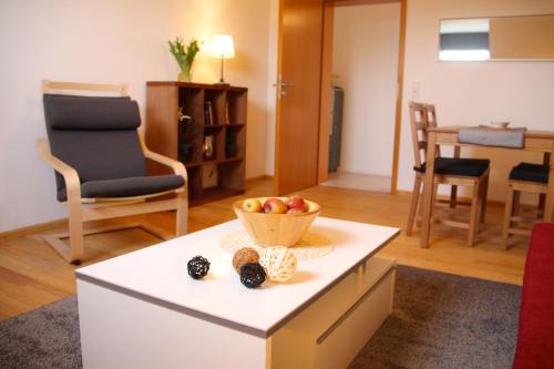 a living room with a bowl of fruit on a table at Ferienwohnung Kirchturmblick Euren in Trier