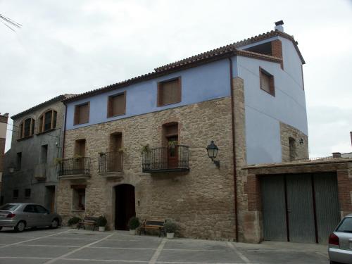 ein großes Steingebäude mit Fenstern und einem Parkplatz in der Unterkunft Cal Manyo in Puigvert de Lérida