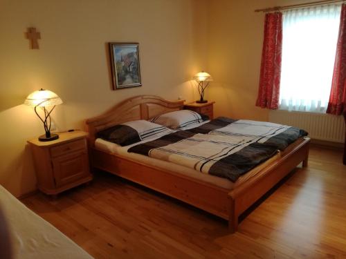 a bedroom with a bed with two lamps and a cross on the wall at Gasthof Kirchenwirt in Lackenhof
