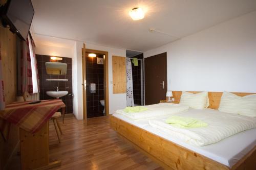 a bedroom with a large bed and a bathroom at Berggasthof Hochzeigerhaus in Jerzens