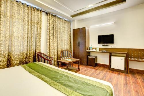 a hotel room with a bed and a desk at Treebo C T International in New Delhi