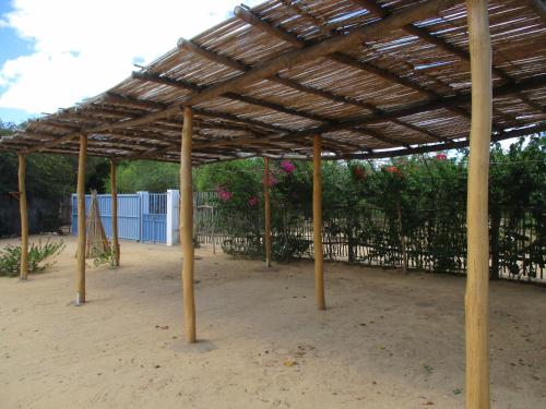 a wooden pavilion with a fence and trees at Le Jardin de L'isle in Ifaty