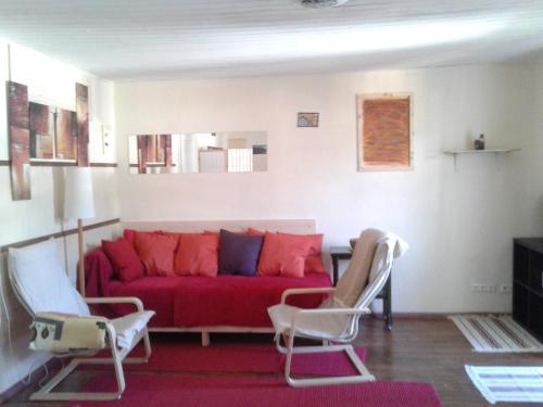 a living room with a red couch and two chairs at Liuis in Bad Ischl