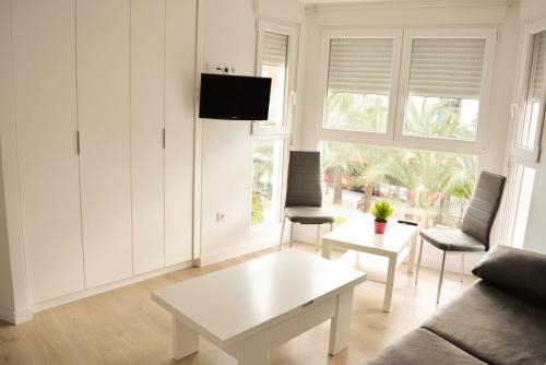 a living room filled with furniture and a tv at Apartamentos San Agustín in Murcia