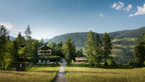 eine Straße, die zu einem Haus in den Bergen führt in der Unterkunft Ferienwohnungen Ötztal in Sautens