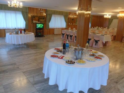 a table with plates of food on it in a room at Hotel Conde in Taboadela