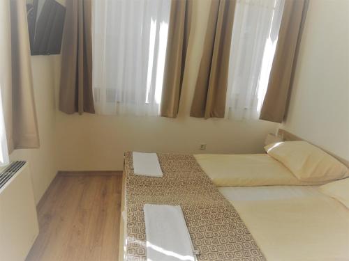 a small bedroom with a bed and a window at Hotel Logavina 8 Garage Parking in Sarajevo