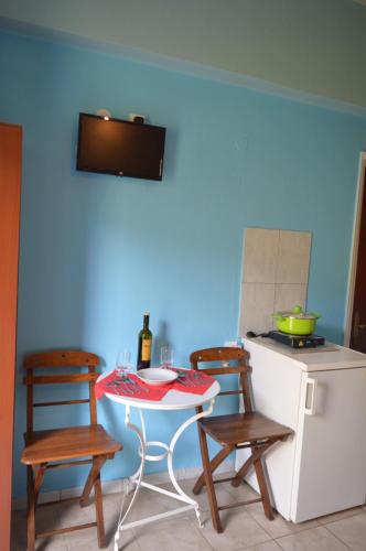 a kitchen with a table and two chairs and a stove at "STELIOS & GALINI" in Symi