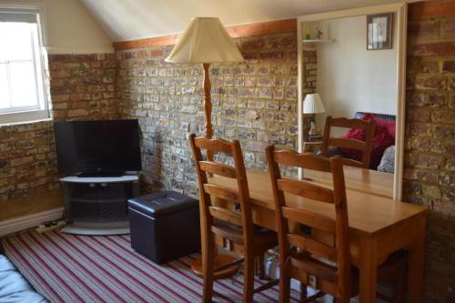 a dining room with a table and a television at St Peters Bed and Breakfast in Sandwich