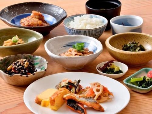 a table with bowls and plates of food on it at Koriyama Washington Hotel in Koriyama