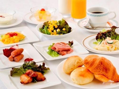 a table with plates of food and a cup of coffee at Koriyama Washington Hotel in Koriyama