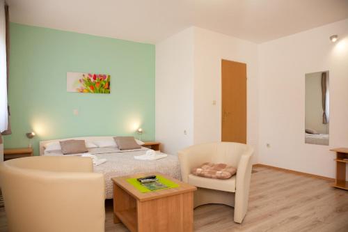 a bedroom with a bed and a table and chairs at Guest House Ljubica in Rastovača